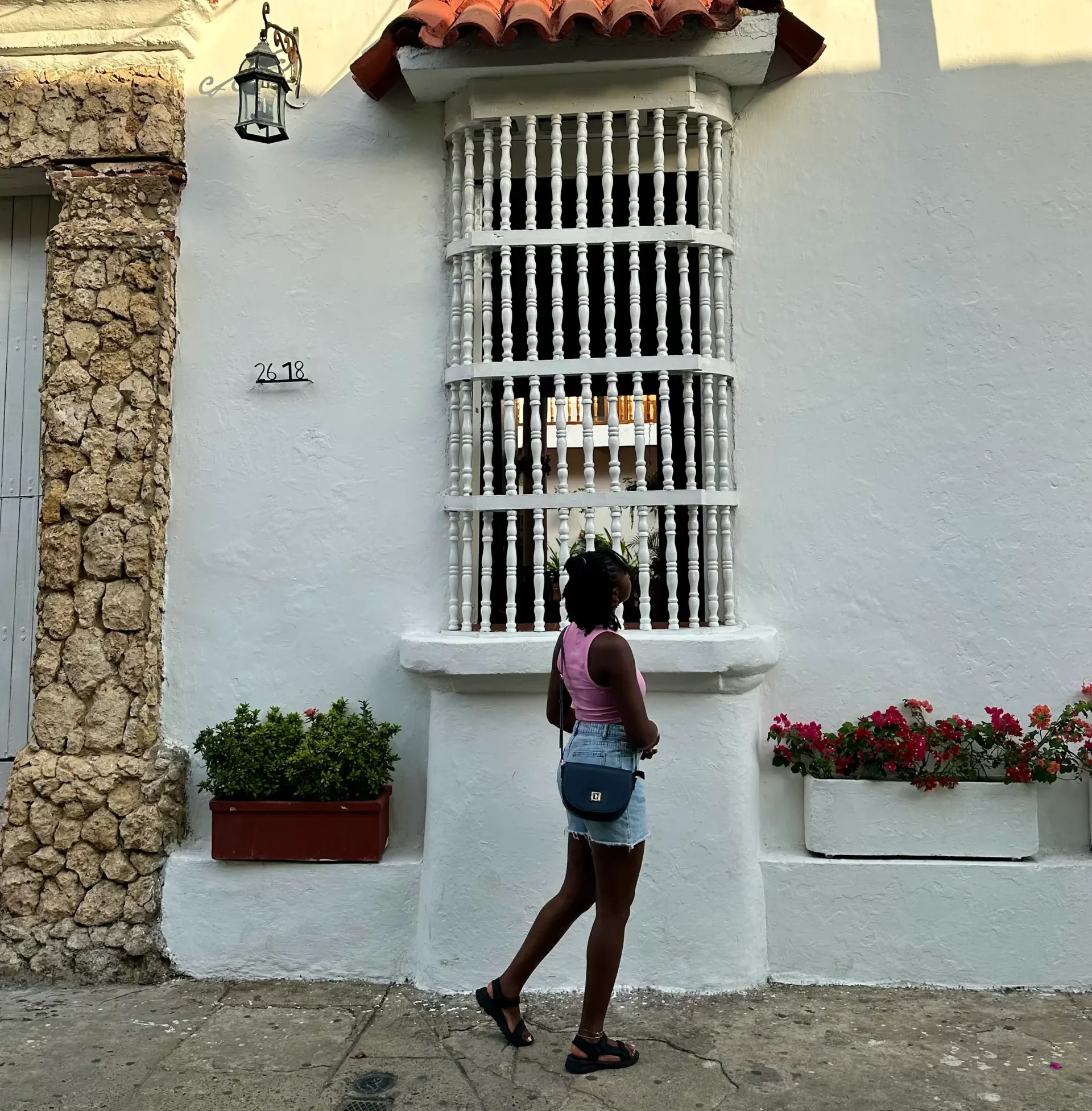 Woman walking with a crossbody bag, travel essentials concept.