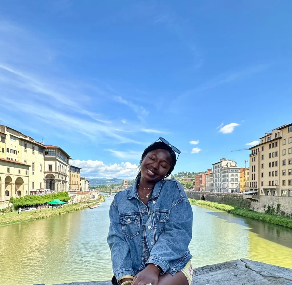 Traveler smiling by the Arno River in Florence, Italy